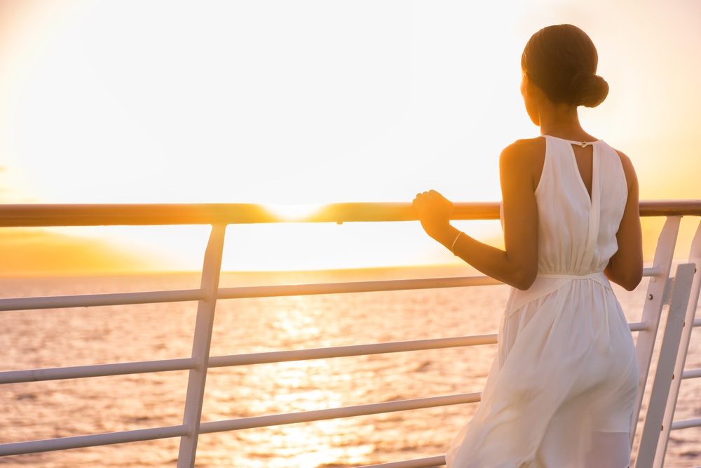 passenger watching sunset from ship deck